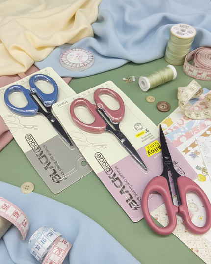 Two pairs of scissors on their packaging with a black background