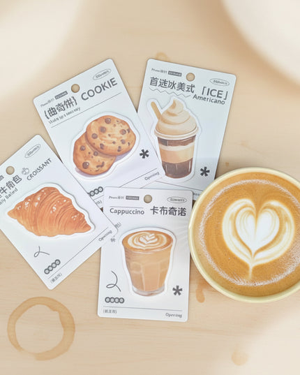 Four packaging cards with food and drink illustrations next to a yellow mug on a dark background
