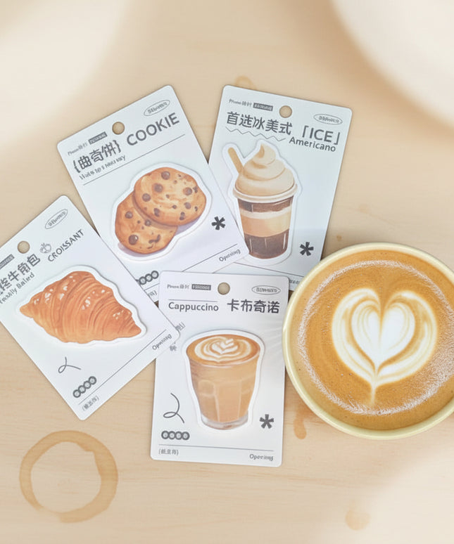 Four packaging cards with food and drink illustrations next to a yellow mug on a dark background