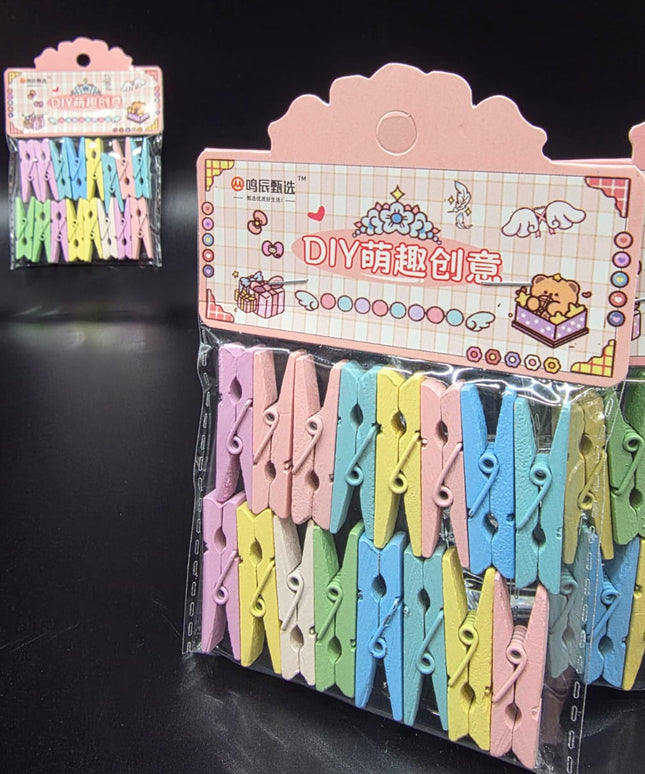 Colorful clothespins in a clear plastic package with a pink display stand on a black background.