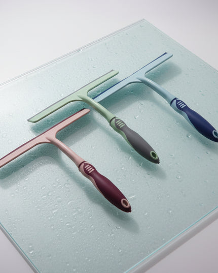 Three squeegees with different colored handles on a white background
