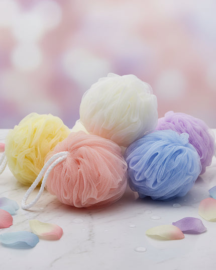 Four colorful bath pouf sponges on a white background