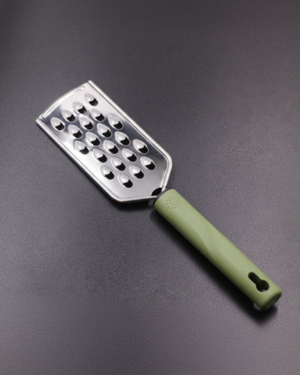 Metal grater with a green handle on a gray background