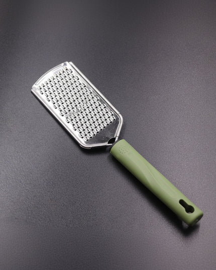Metal grater with green handle on a gray background
