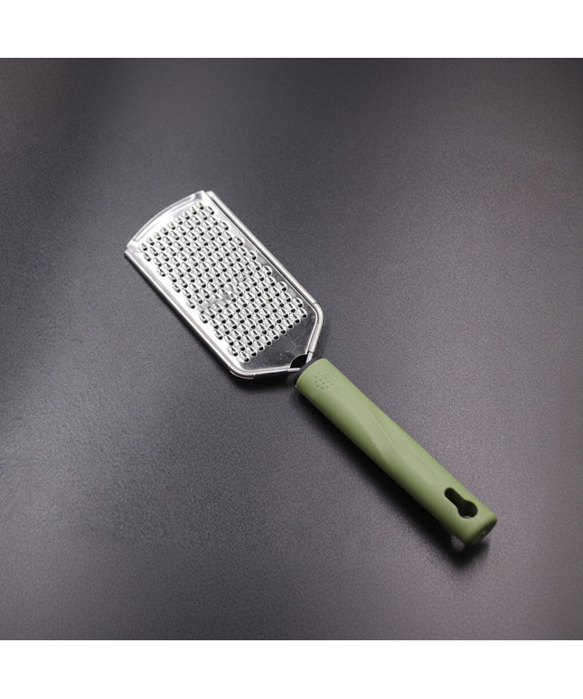 Metal grater with green handle on a gray background