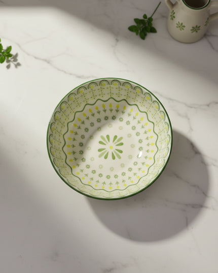 Decorative ceramic plate with green floral pattern on a white background
