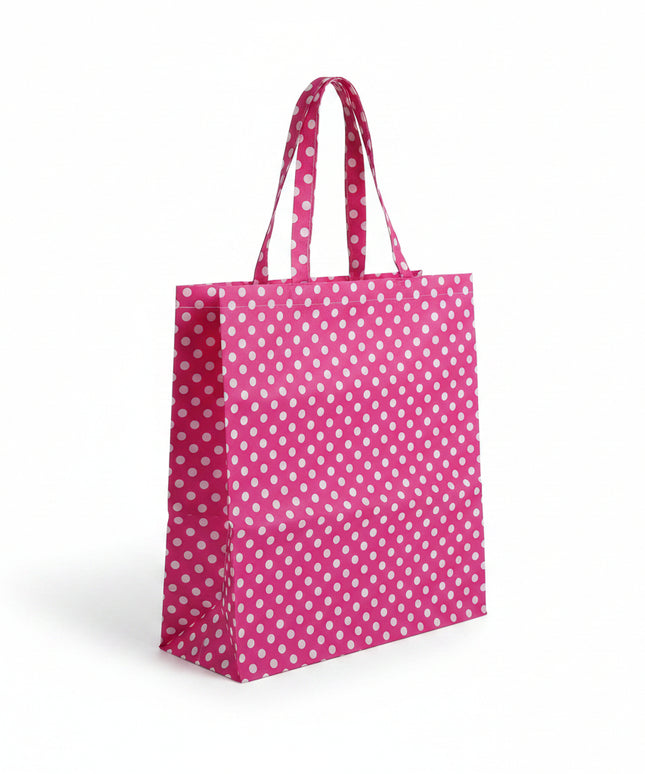 Pink tote bag with white polka dots on a light gray background