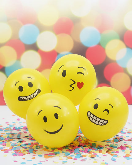 Yellow balloons with various emoji faces on a white background