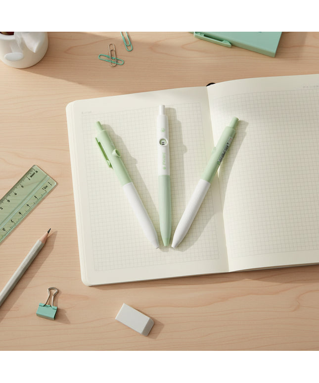 Two green and white pens on a light gray background