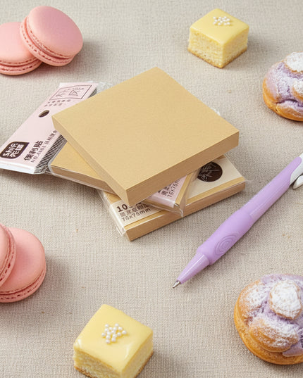 Stack of yellow sticky notes with a purple pen on a dark surface