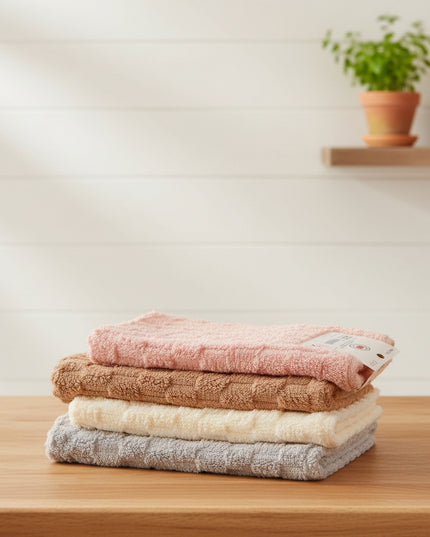 Stack of four textured bath towels in pink, brown, beige, and gray on a light gray background.