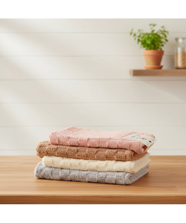 Stack of four textured bath towels in pink, brown, beige, and gray on a light gray background.