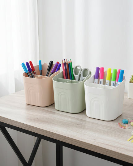 Three small storage bins in beige, green, and white on a cardboard surface.