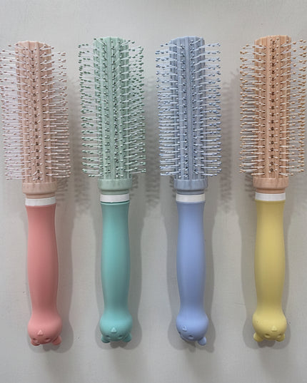 Four colorful hairbrushes with different handle colors on a light gray background