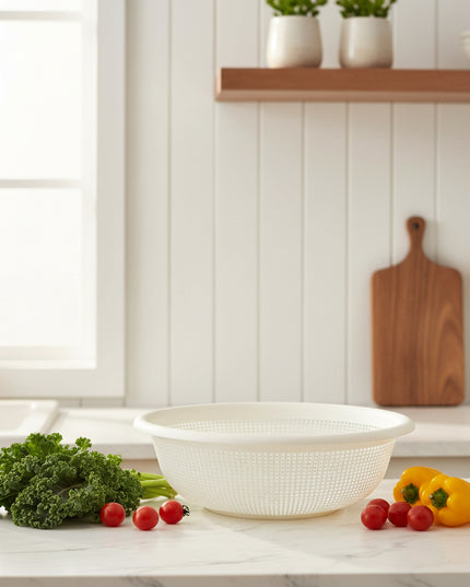 White plastic colander on a cardboard box with a white wall and boxes in the background