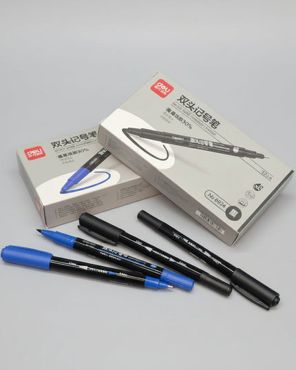 Two blue markers and two black markers with their packaging on a dark surface