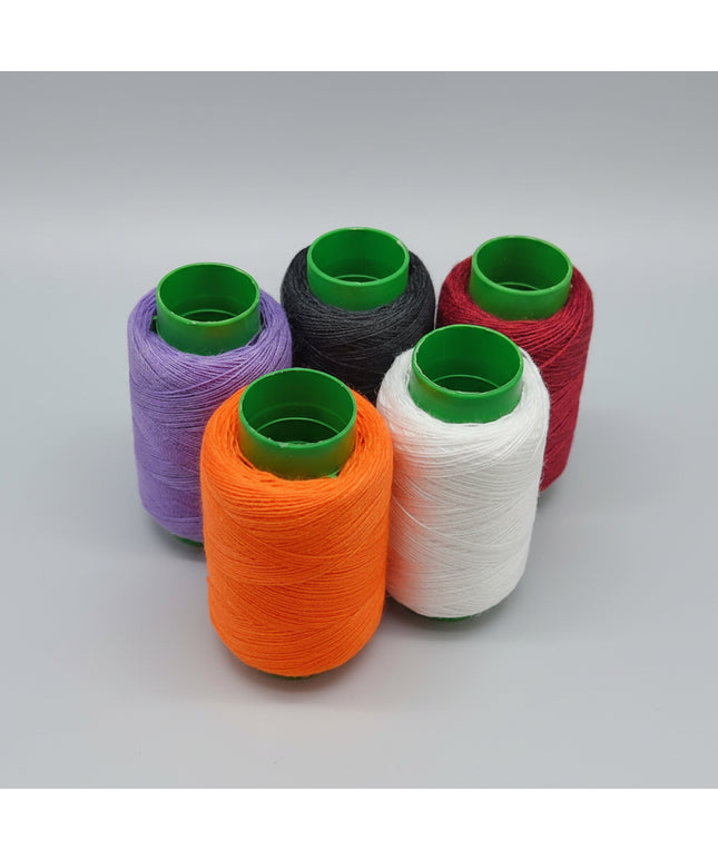 Set of colorful spools of thread on a dark background