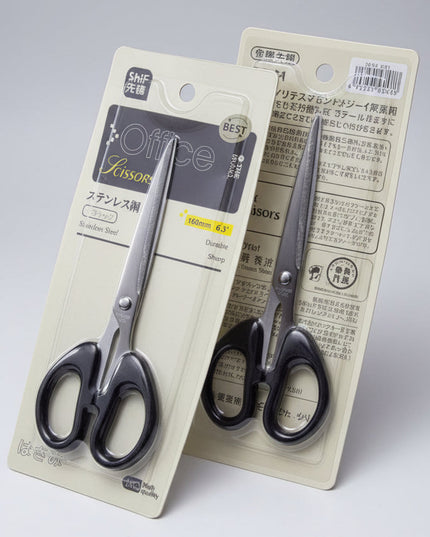 Two pairs of office scissors in their packaging on a dark background
