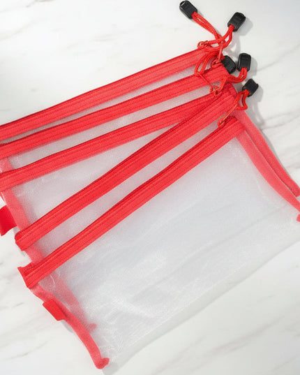 Set of clear plastic bags with red zippers on a dark background