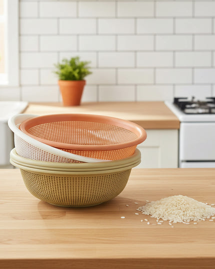 Two strainers stacked on a cardboard box with a white wall in the background.