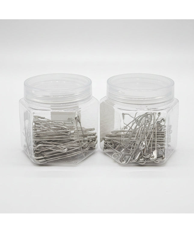 Two clear plastic jars filled with metal hairpins on a black background