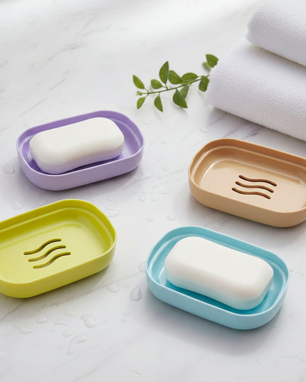 Four colorful soap dishes on a dark surface