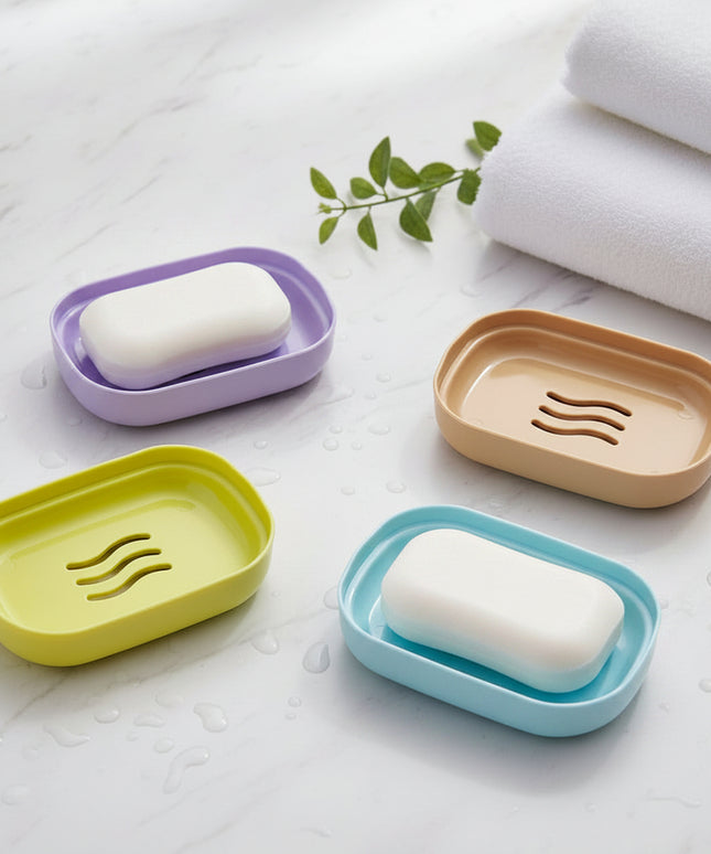 Four colorful soap dishes on a dark surface
